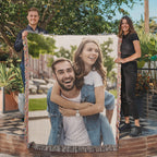Two people holding the woven photo blanket in a garden